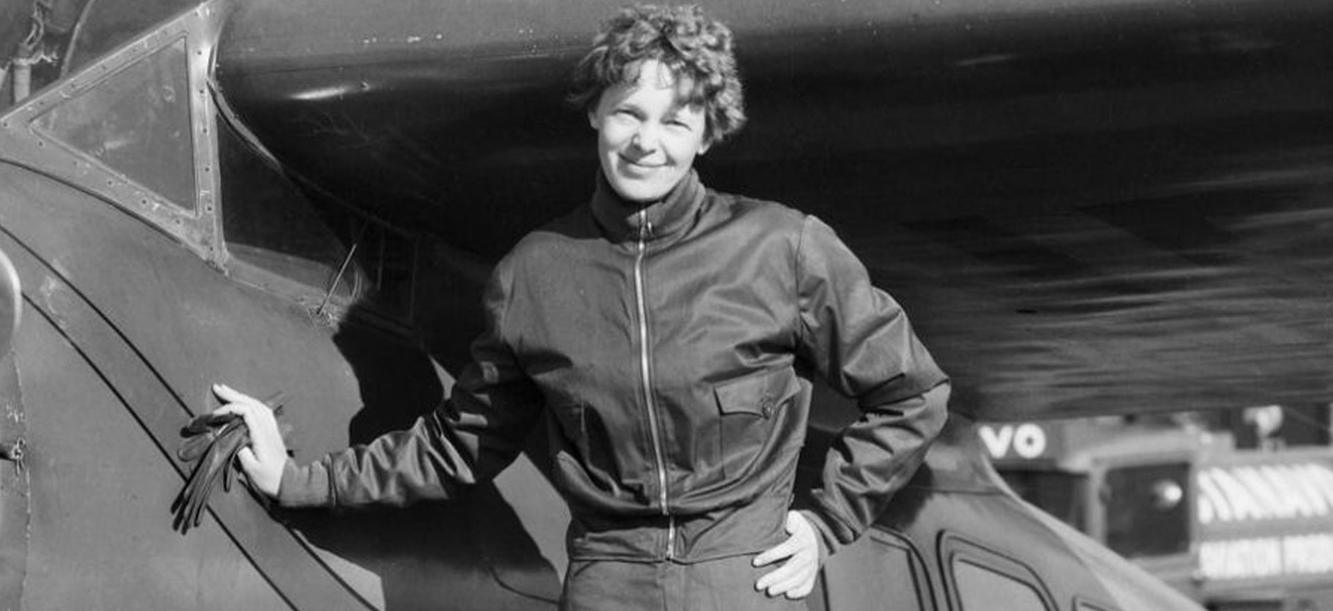 Amelia Earhart posando orgullosa junto a su confiable avión